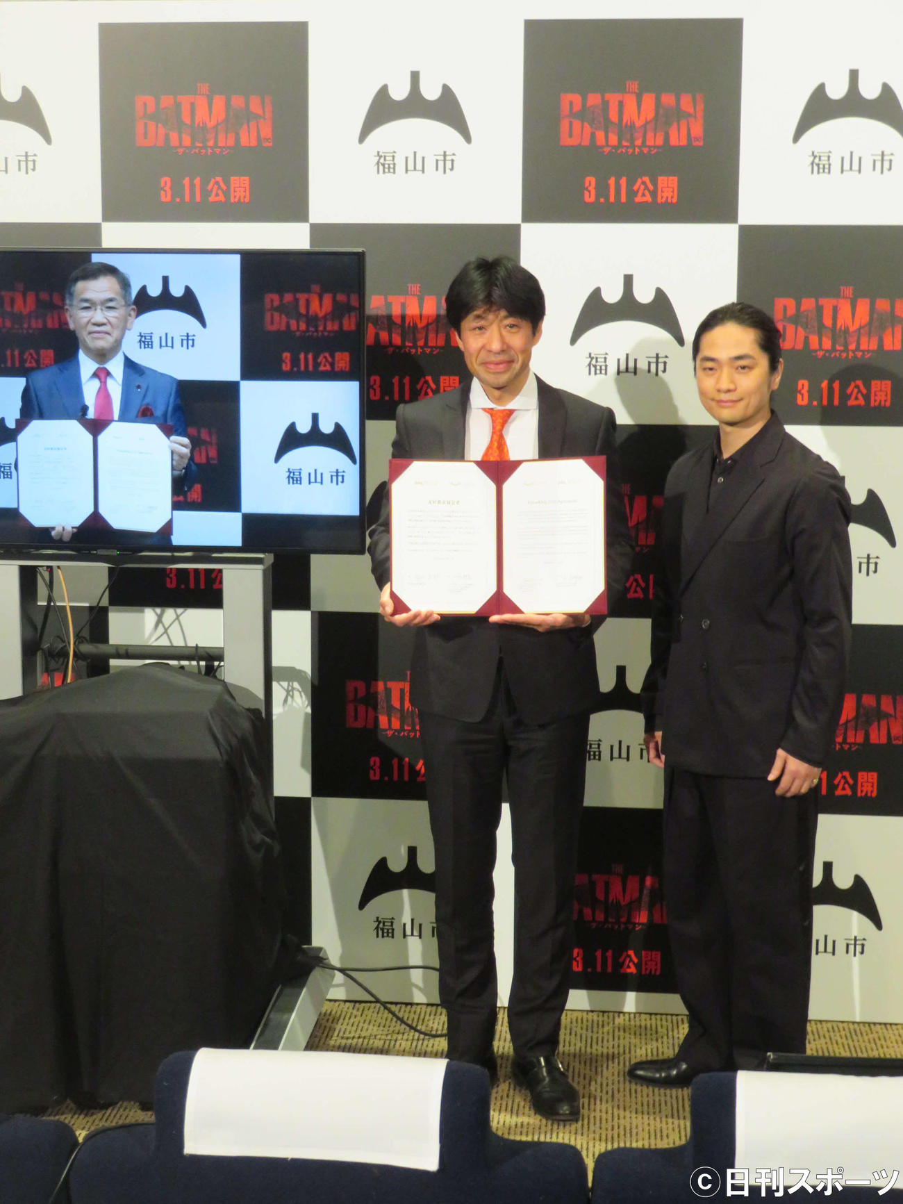 「バットマン」の舞台ゴッサム・シティと広島県福山市との友好都市提携調印式を行った、左から福山市の枝広直幹市長、ワーナーブラザースジャパンの土合明宏氏、福山潤（撮影・村上幸将）