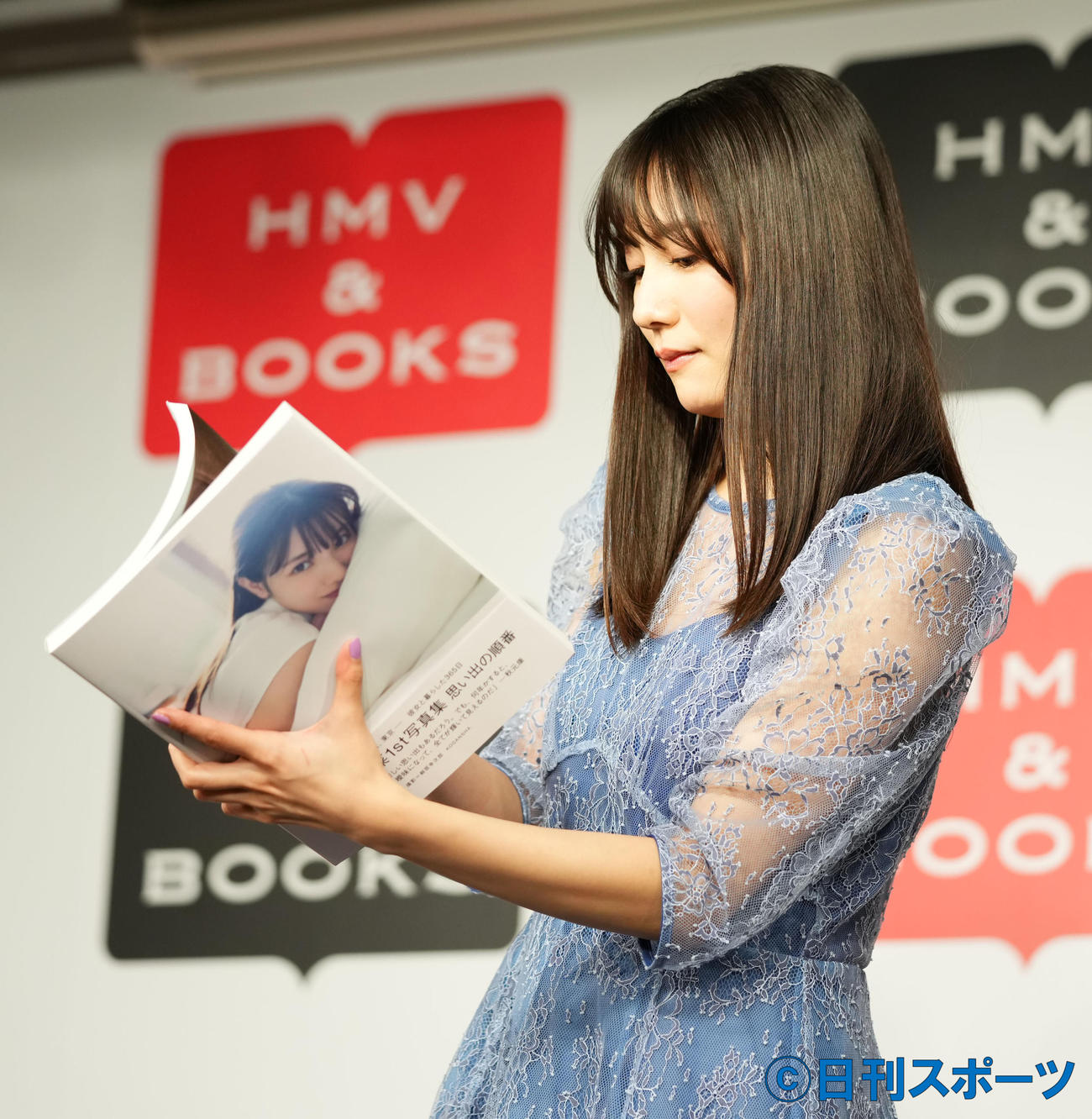 写真集のお気に入りページを探す日向坂46の河田陽菜（撮影・横山健太）