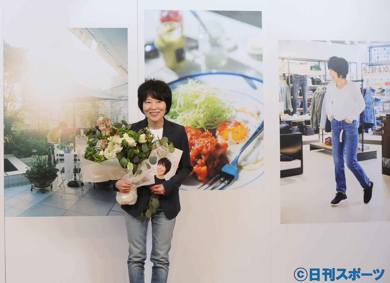 新雑誌発表会に出席した栗原さん。背後の写真は雑誌内に掲載（撮影・山口昌久）