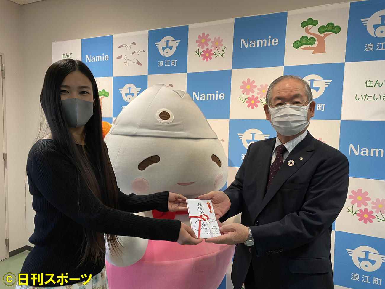 出身地の浪江町の吉田数博町長（右）に義援金を手渡す牛来美佳