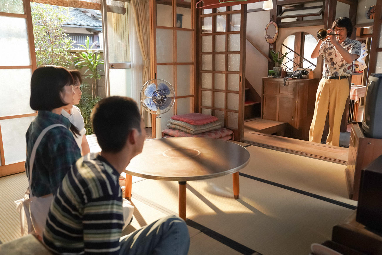 「大月」の茶の間にて。トランペットを手にした錠一郎を見るるいたち。左から、大月るい（深津絵里）、大月ひなた（川栄李奈）、大月桃太郎（青木柚）、大月錠一郎（オダギリジョー）（Ｃ）NHK