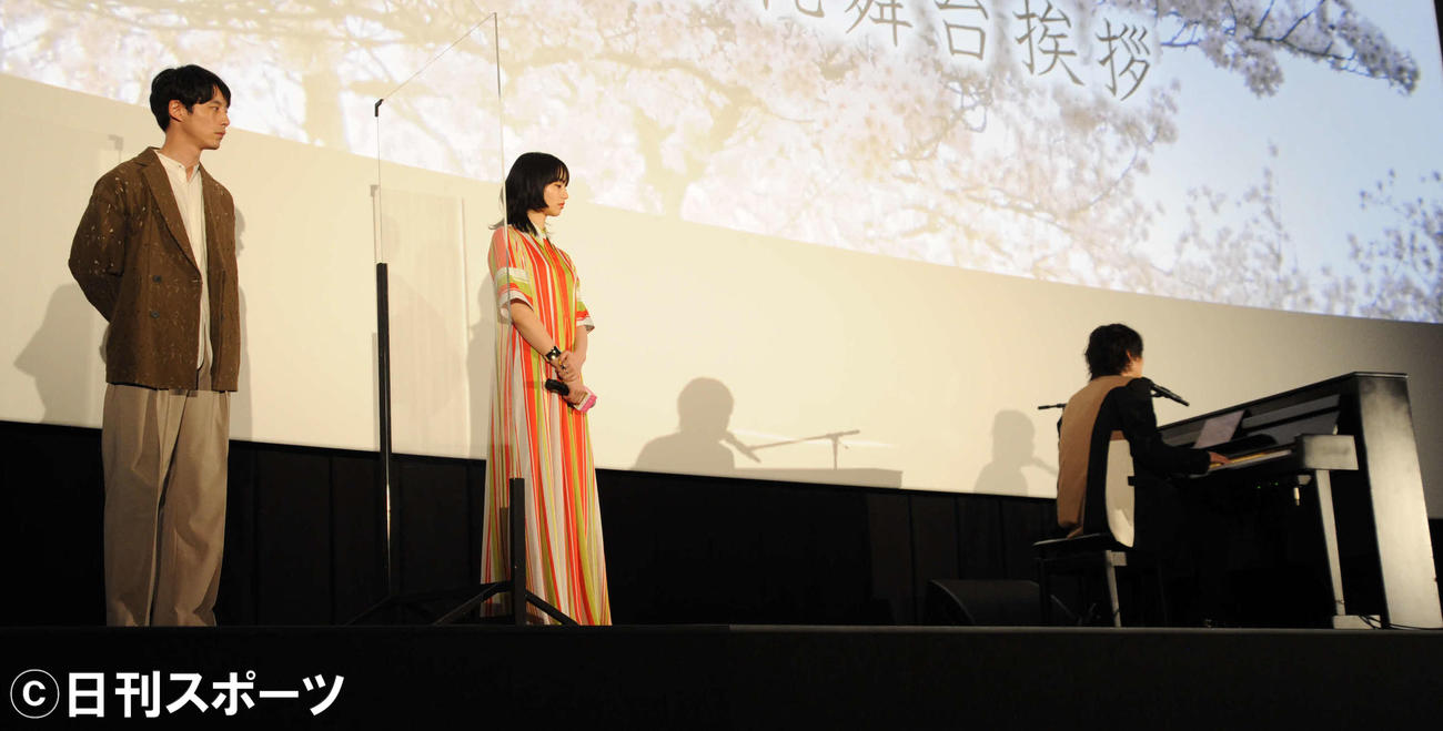映画「余命10年」大ヒット御礼舞台あいさつで、サプライズ登場したRADWIMPS野田洋次郎（右端）の歌う主題歌「うるうびと」を聞く小松菜奈（中央）と坂口健太郎