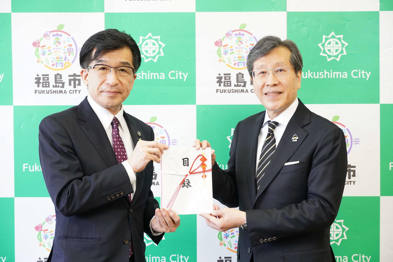 寄付目録を手渡すJASRAC浅石道夫理事長（右）と福島市の木幡浩市長
