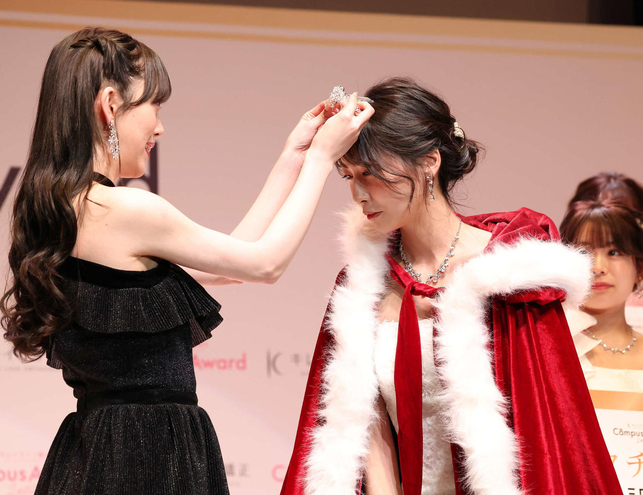 グランプリに選ばれてプレゼンターの堀未央奈（左）からティアラをつけてもらう藤井珠生（撮影・丹羽敏通）