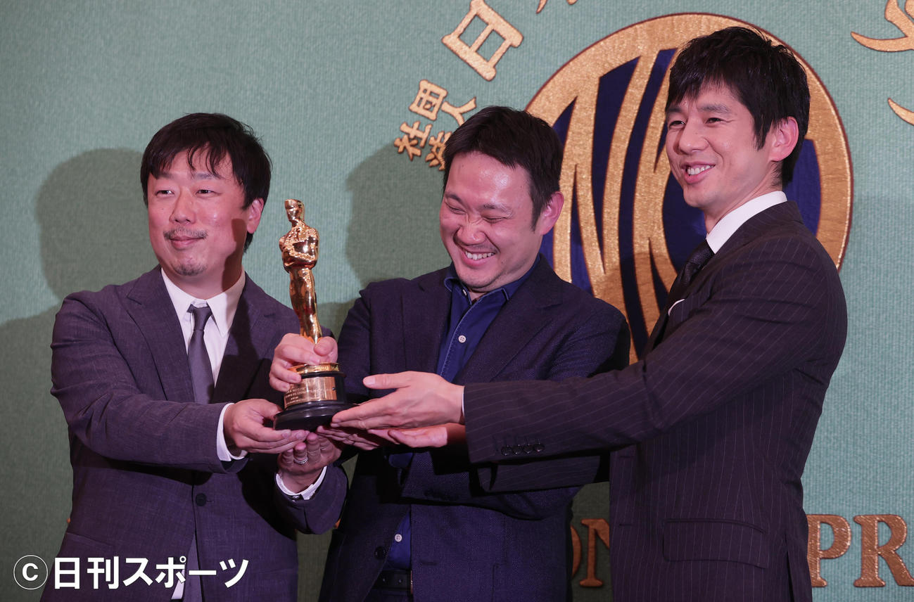 米アカデミー賞で国際長編映画賞を受賞し、日本記者クラブで会見したドライブ・マイ・カーの左から山本晃久プロデューサー、濱口竜介監督、主演の西島秀俊は、オスカー像を手に笑顔（撮影・野上伸悟）