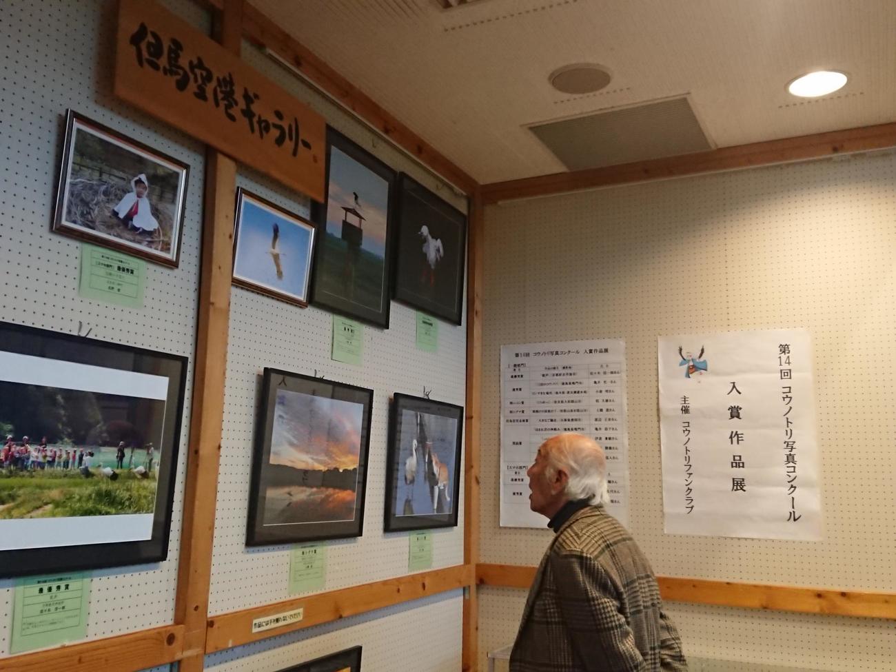19年に「第14回コウノトリ写真コンクール」入賞作品展を訪れた柳生博さん（コウノトリファンクラブ提供）