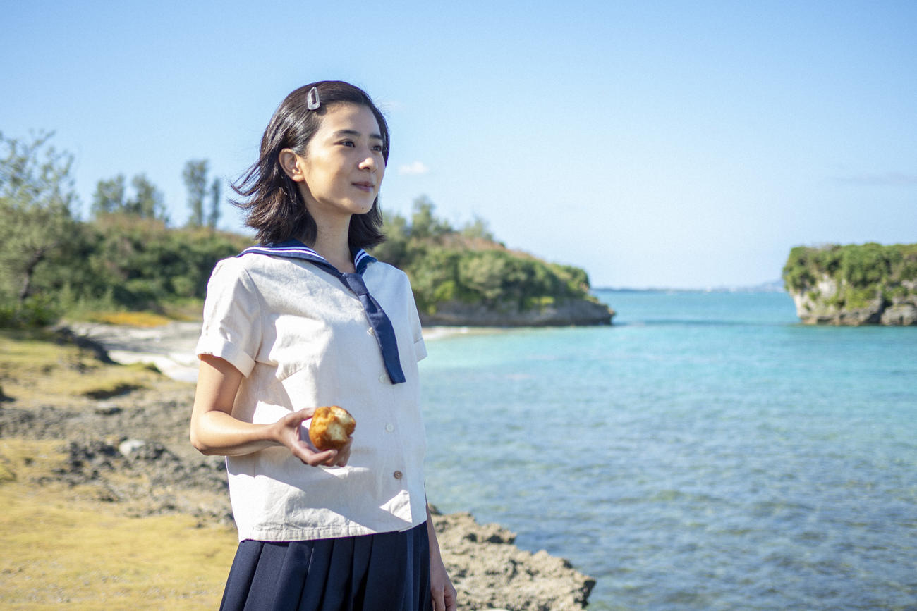 朝ドラ「ちむどんどん」より。比嘉暢子（右＝黒島結菜）はサーターアンダギーを手に海辺に立つ（C）NHK
