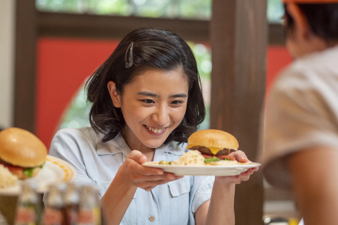 朝ドラ「ちむどんどん」より。ハンバーガーに目を輝かせる比嘉暢子（黒島結菜）（C）NHK