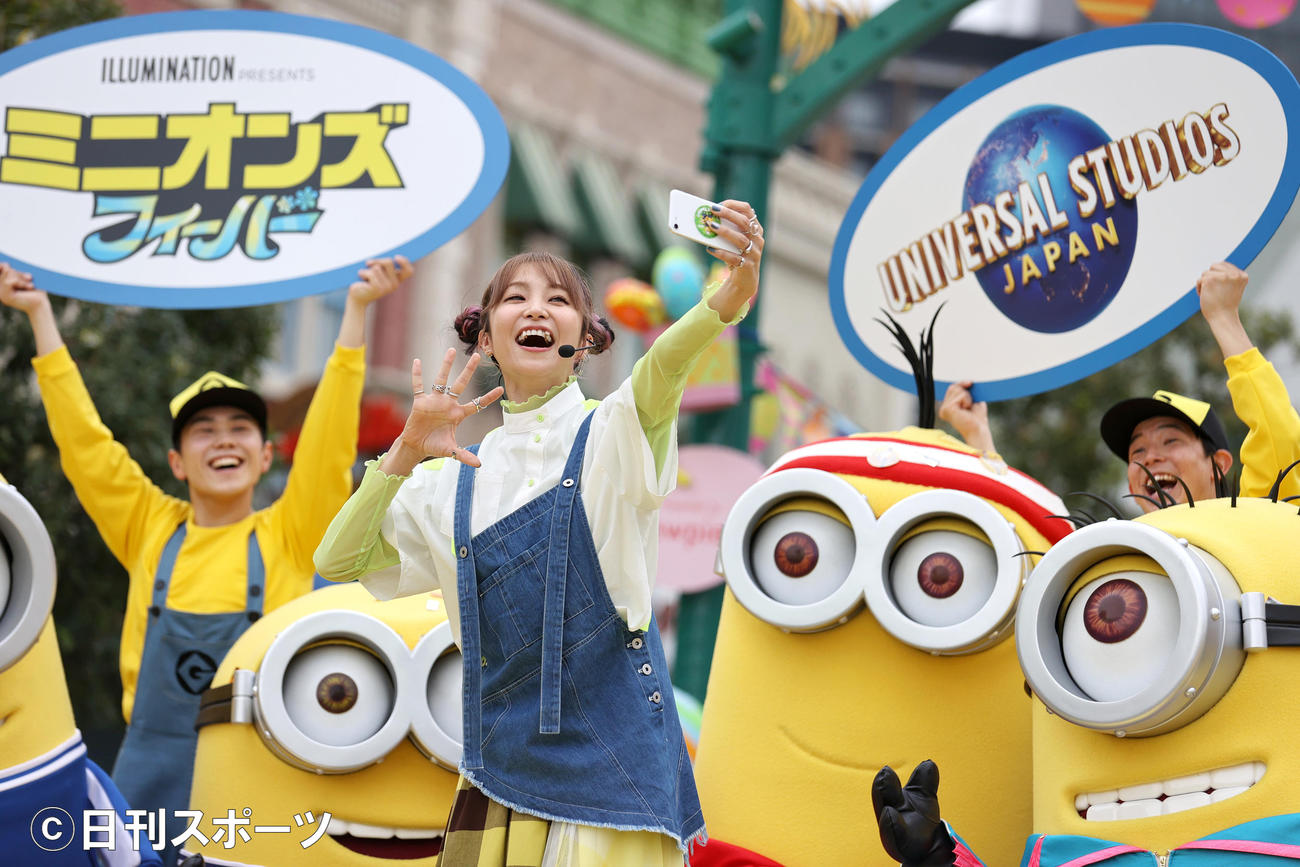 「ミニオン・パーク」オープン5周年アニバーサリー・イベントでミニオンたちとスマホで写真を撮るLiSA（撮影・上山淳一）
