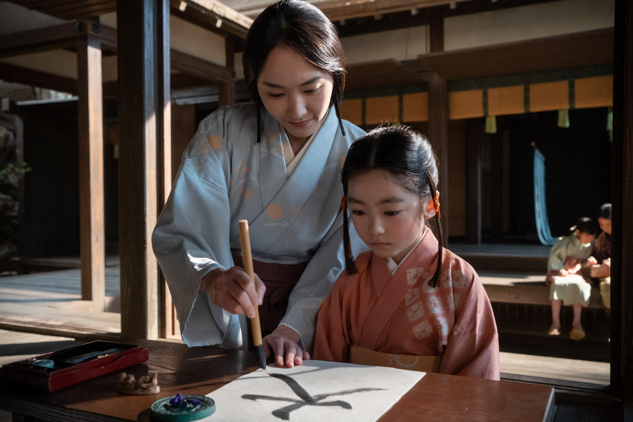 大河ドラマ「鎌倉殿の13人」より。鎌倉・義時の館にて。たくさんの子どもを預かって育てている八重（新垣結衣）が、元気のない大姫に習字を教える（C）NHK