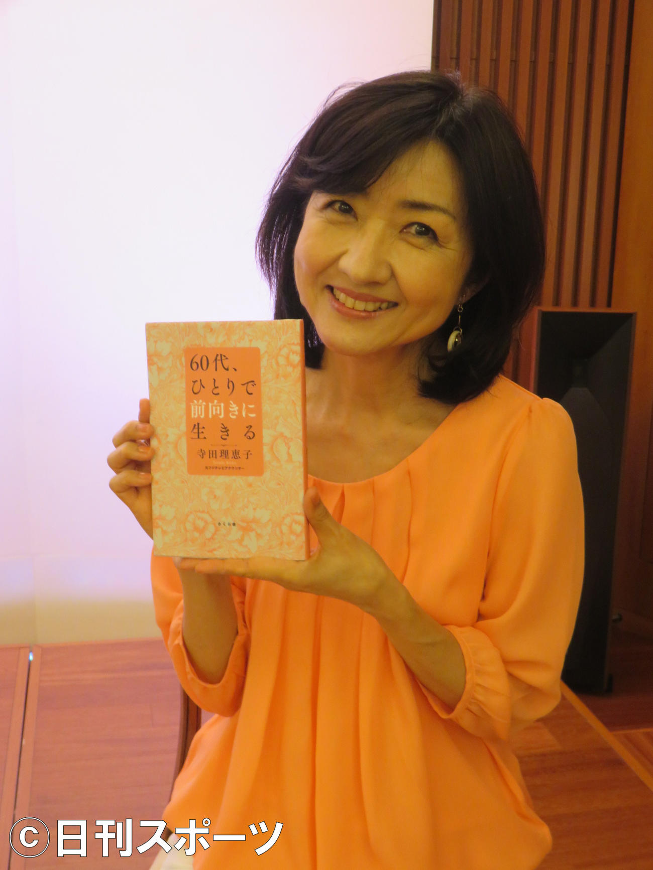 著書「60代、ひとりで前向きに生きる」を手にする寺田理恵子