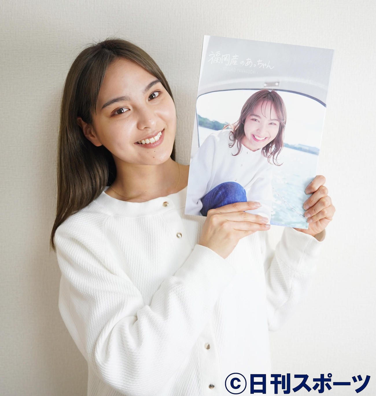 ファースト写真集を手に、笑顔をみせる山口厚子（撮影・佐藤勝亮）