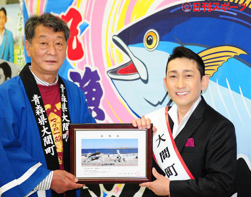 青森県大間町の野崎尚文町長（左）から、観光大使の委嘱状を受け取る福田こうへい