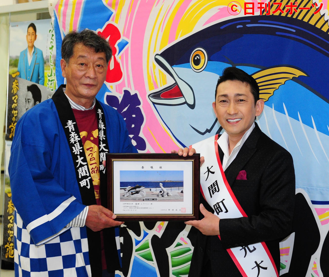 青森県大間町の野崎尚文町長（左）から、観光大使の委嘱状を受け取る福田こうへい