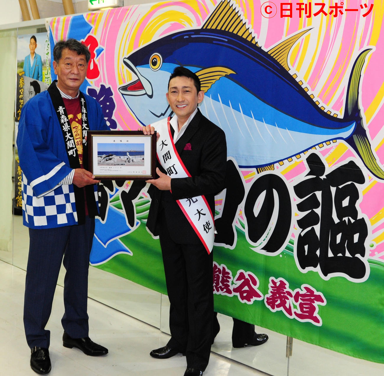 青森県大間町の野崎尚文町長（左）から、観光大使の委嘱状を受け取る福田こうへい