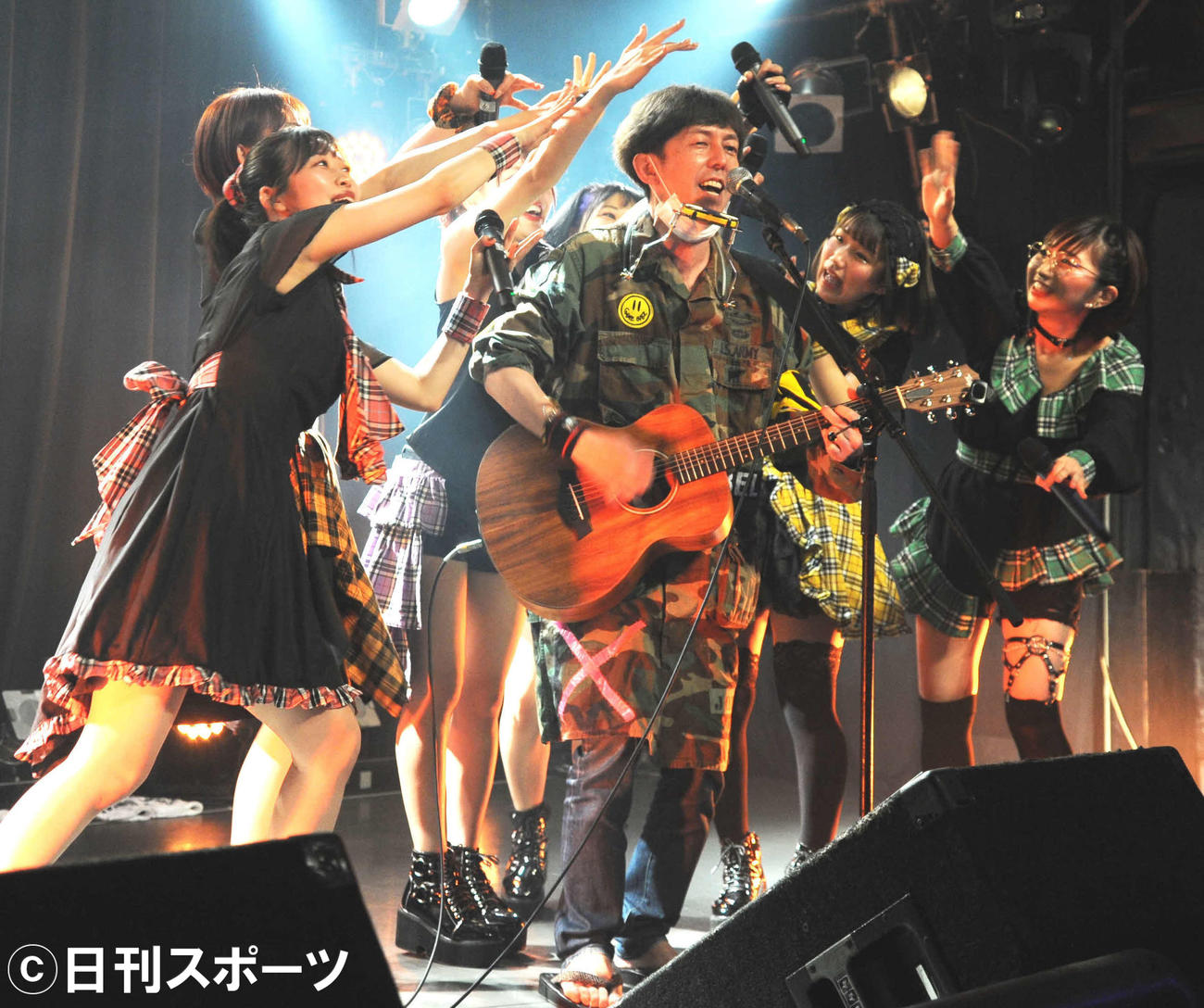 女性6人組アイドルグループ、アイアイタイガーの単独ライブでメンバーに囲まれながら弾き語りを披露する、お笑いコンビ2丁拳銃の小堀裕之（撮影・松尾幸之介）