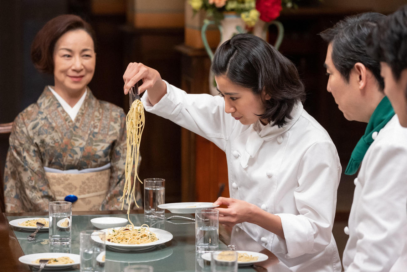朝ドラ「ちむどんどん」より。ペペロンチーノ対決で料理を皿に取り分ける比嘉暢子(左から2人目＝黒島結菜)（C）NHK
