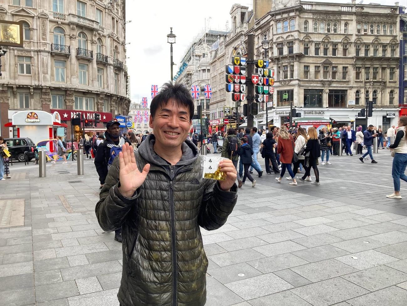 22年、イギリス・ロンドンで、「ブリテンズ・ゴット・タレント（BGT）」で獲得した「ゴールデンブザー」の金テープを持って笑顔を見せる岩崎圭一氏