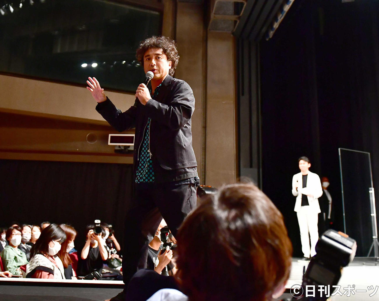 映画「神は見返りを求める」完成披露試写会で会場に設置された花道を歩いてあいさつするムロツヨシ。右は岸井ゆきの（撮影・小沢裕）
