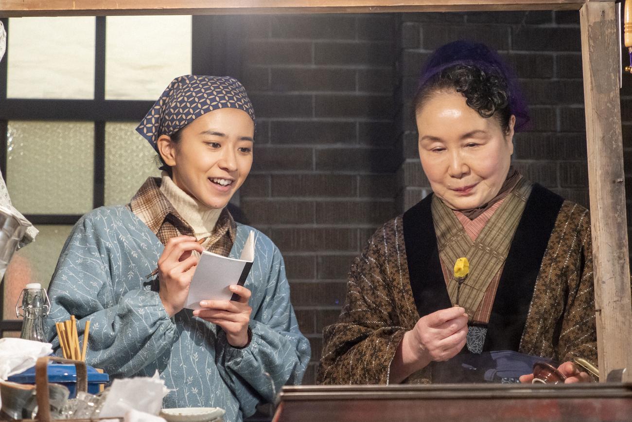 朝ドラ「ちむどんどん」より。安孫子ヨシ（右＝大島蓉子）におでんについて教わり、メモを取る比嘉暢子（黒島結菜）（C）NHK

