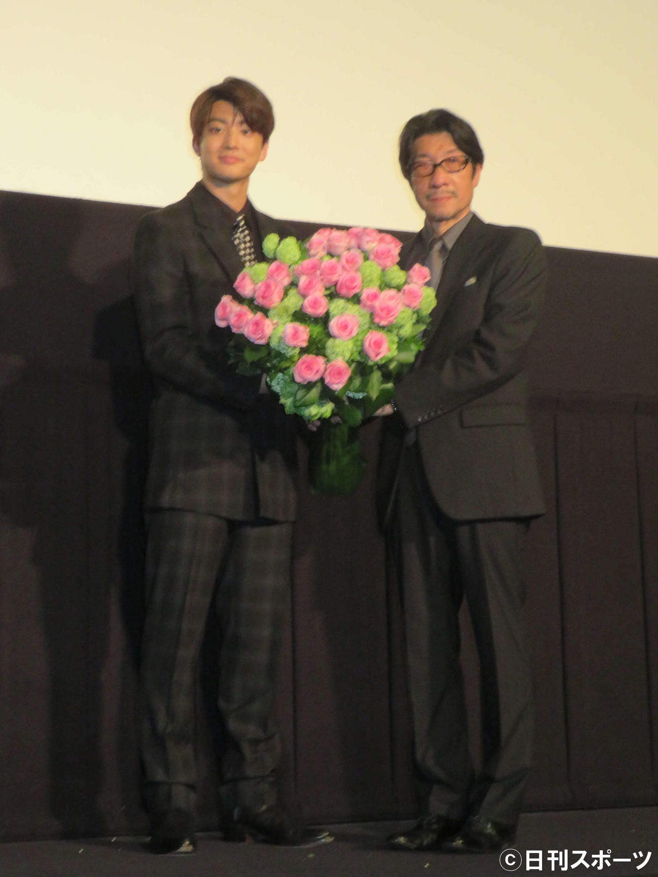 映画「冬薔薇」初日舞台あいさつで阪本順治監督（右）にバラの花束を贈った伊藤健太郎（撮影・村上幸将）