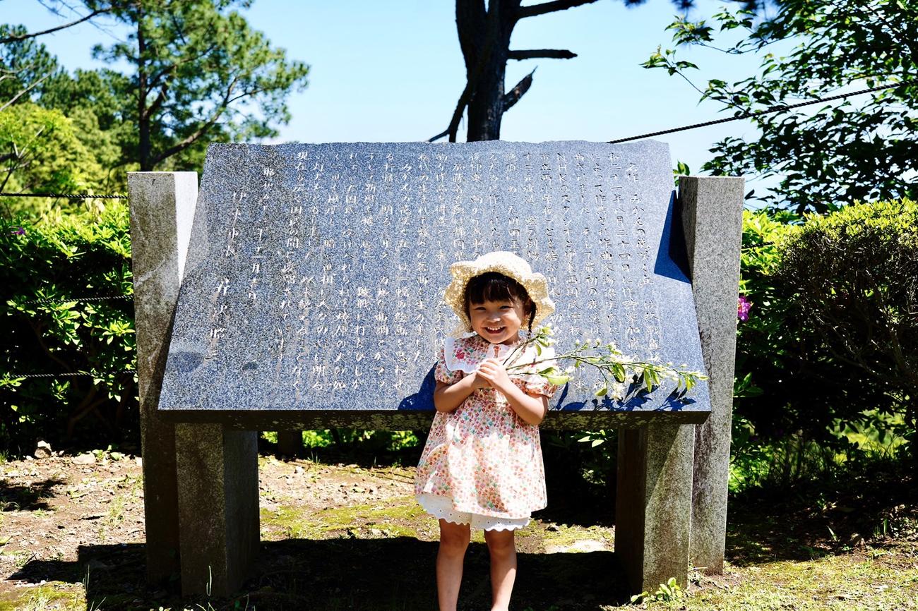 「みかんの花咲く丘」歌碑の前に立つ、ののちゃん