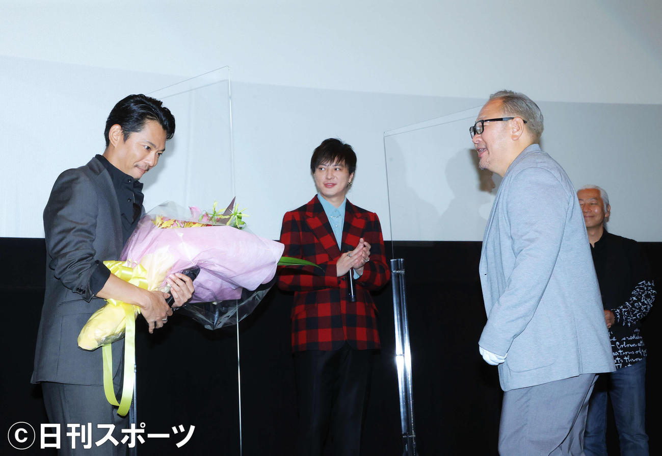 「TELL ME　～hideと見た景色～」完成披露上映会で今井翼（左）は原作者でhideさんの弟の松本裕士氏から花束を受け取る（撮影・河田真司）