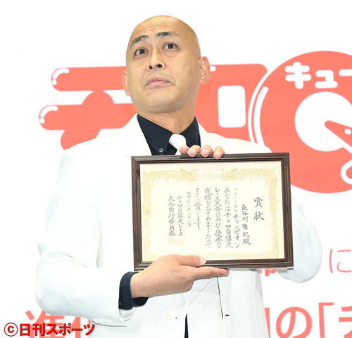 幼少期に「チョロQ」爆走レース大会で優勝した賞状を誇らしげに披露する錦鯉の長谷川雅紀（撮影・滝沢徹郎）
