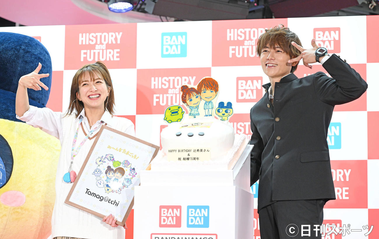 バンダイ・BANDAI SPIRITSブースのオープニングセレモニーで制服姿で登場し記念撮影する辻希美（左）と杉浦太陽（撮影・滝沢徹郎）