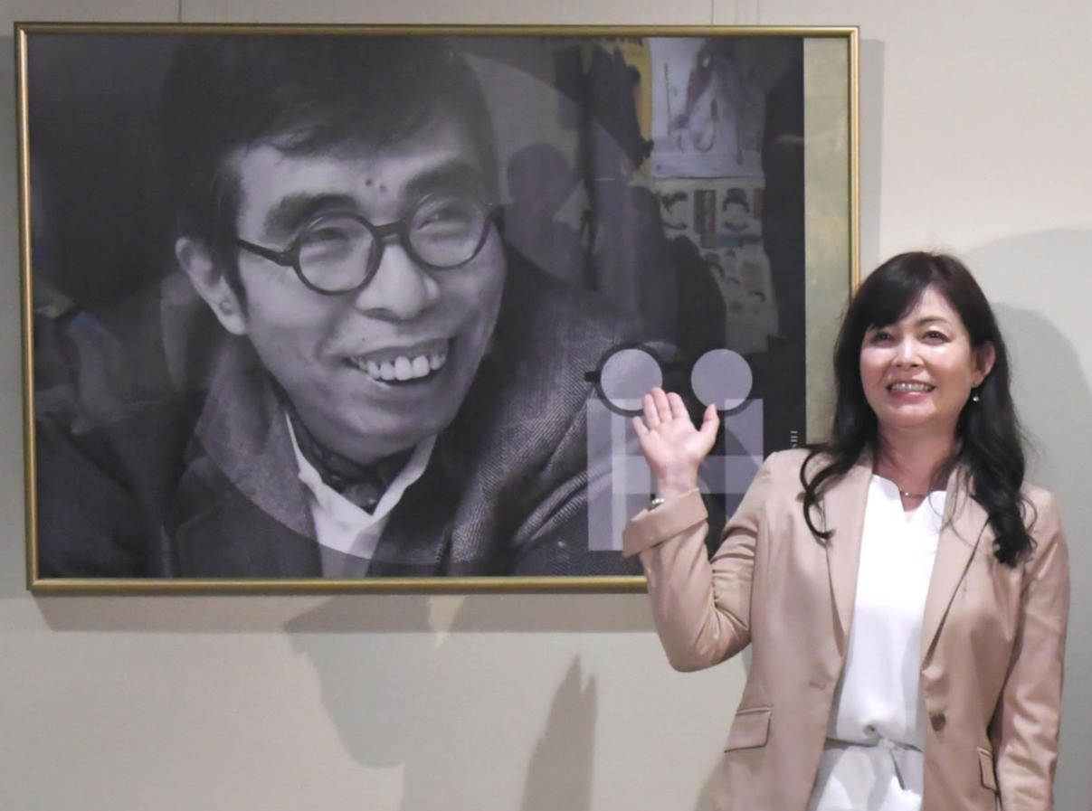 井上ひさし氏のリトグラフの前で記念撮影する井上氏の三女麻矢さん（2021年6月9日撮影）