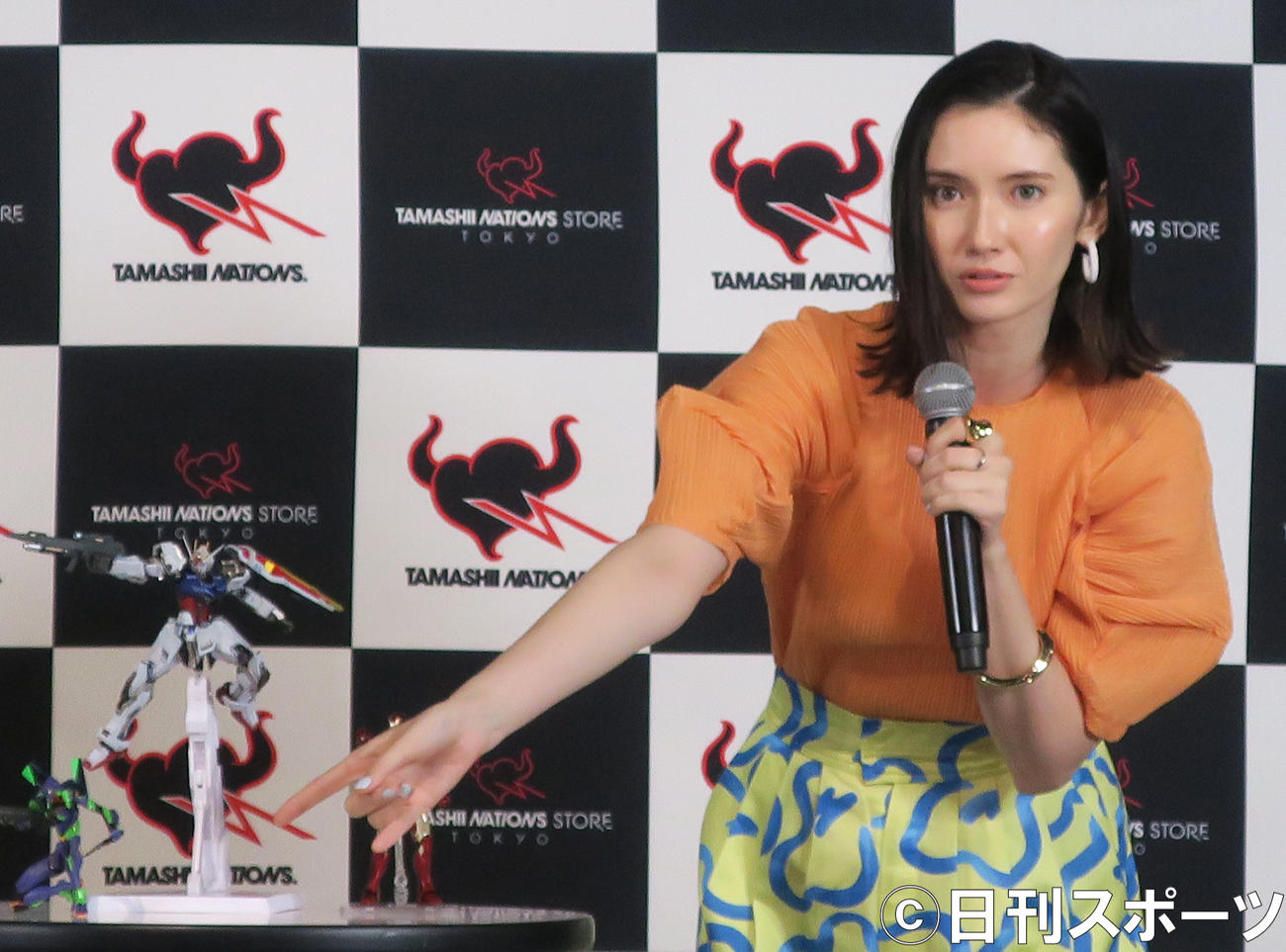 「TAMASHII NATIONS STORE TOKYO」リニューアルオープンセレモニーで、ガダムシリーズのフィギュアを解説する市川紗椰