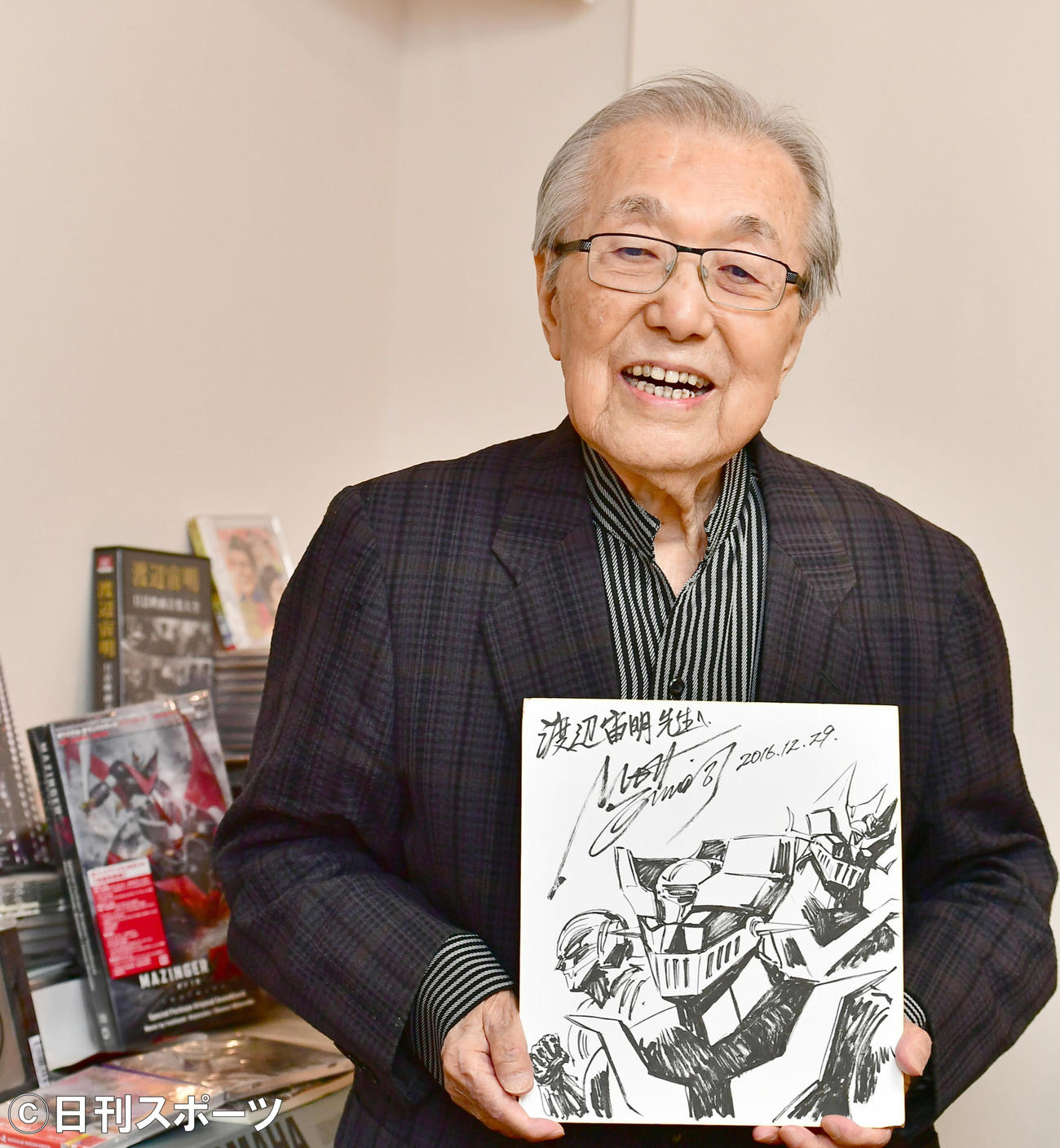 アニメ「マジンガーZ」の色紙を手に笑顔を見せる渡辺宙明氏（2018年撮影）