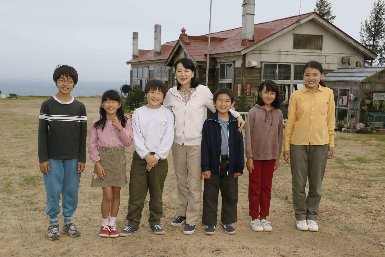2012年の映画「北のカナリアたち」撮影時に、麗端小学校岬分校をバックに記念撮影する、左から相良飛鷹、飯田汐音、菊池銀河、吉永小百合、小笠原弘晃、渡辺真帆、佐藤純美音(C)2012「北のカナリアたち」製作委員会