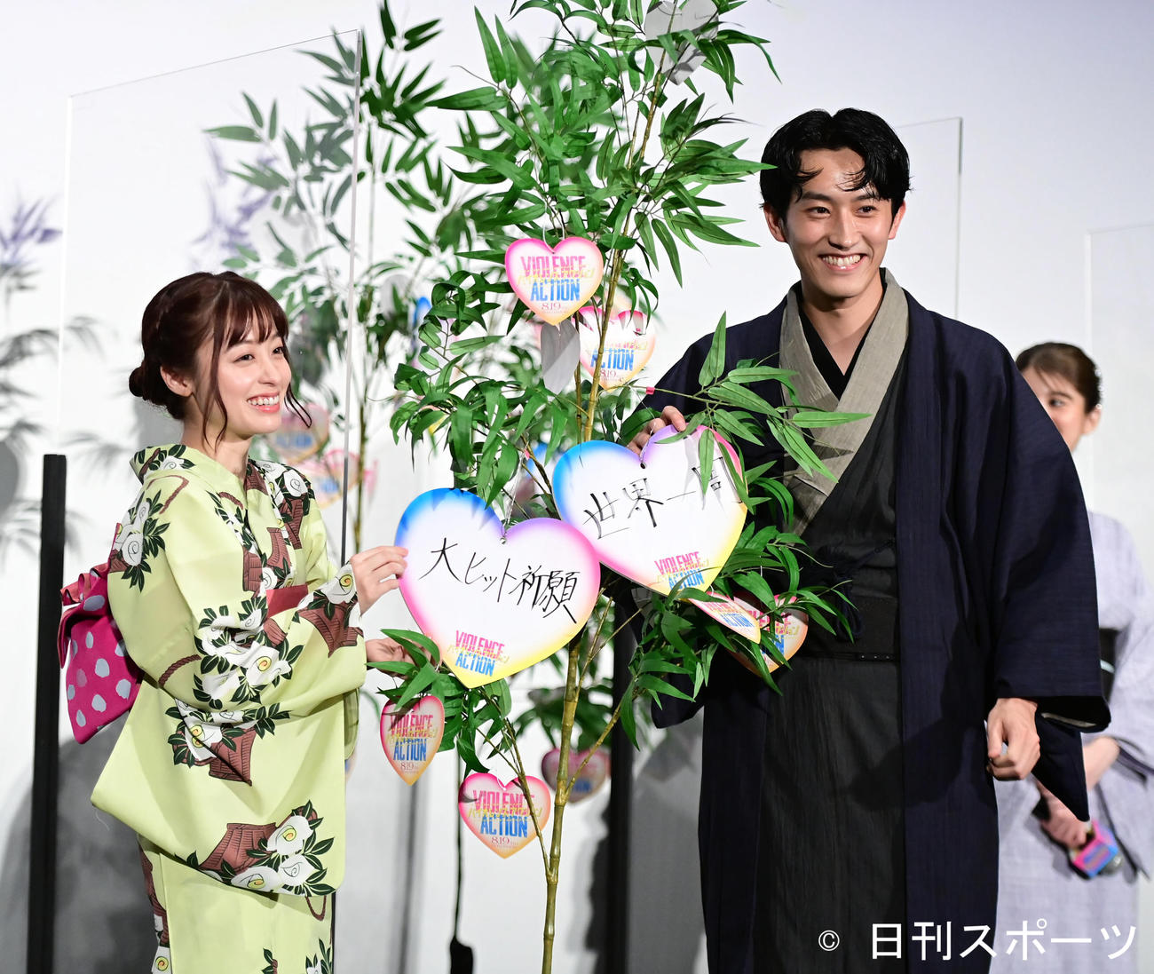 映画「バイオレンスアクション」完成披露試写会舞台あいさつで七夕の願いをしたためた短冊を笹に取り付ける橋本環奈（左）と杉野遙亮（撮影・小沢裕）