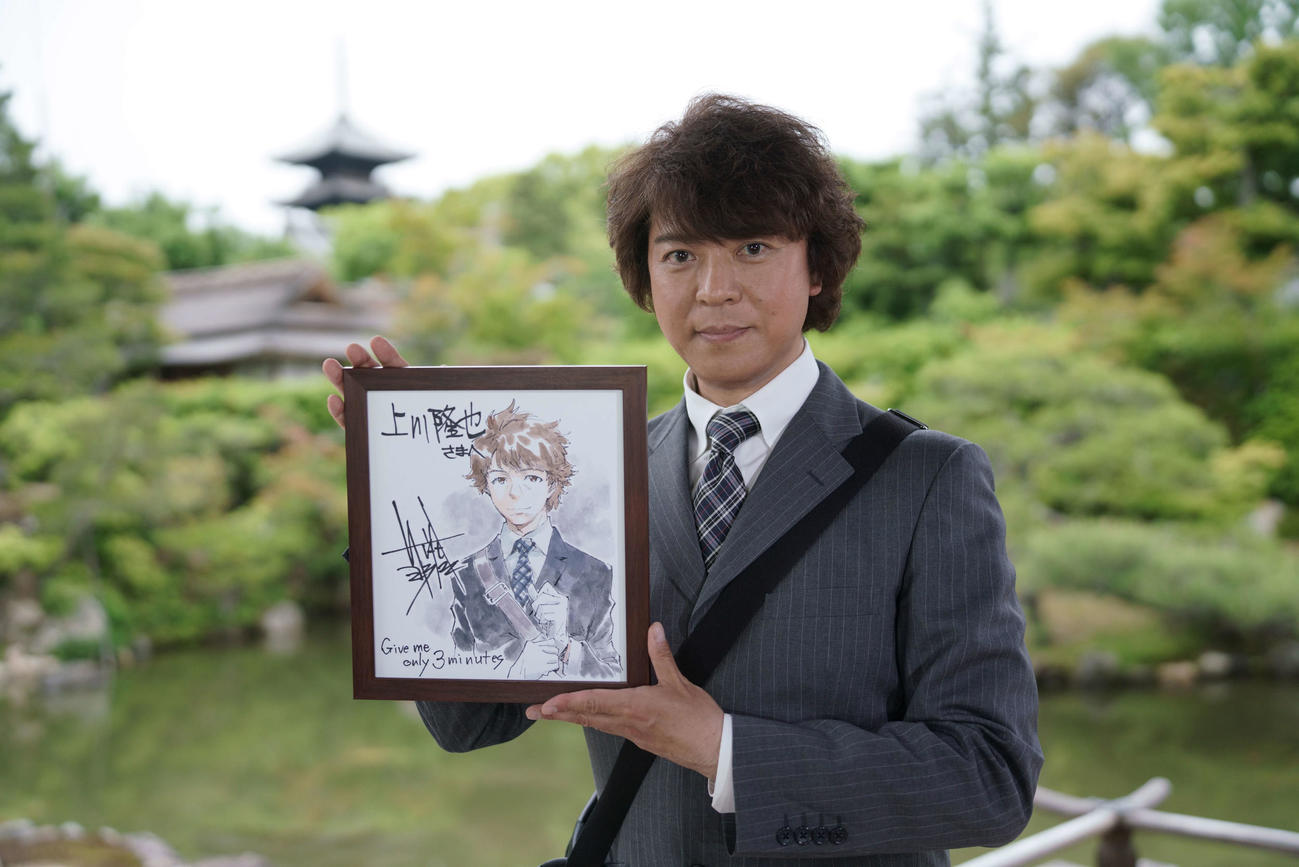 人気漫画家の貞本義行氏が描きおろしたイラスト色紙を手にする上川隆也