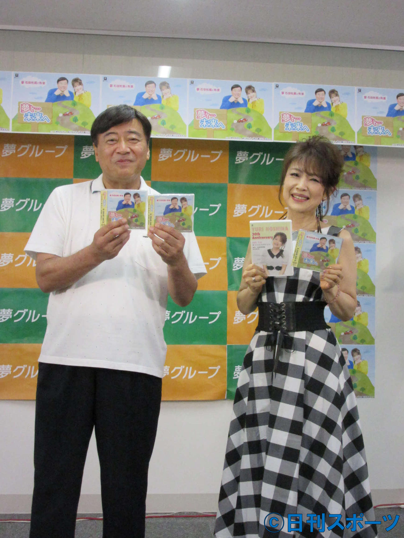 歌手デビューCDを手にする石田重廣社長（左）と保科有里（8日、東京・文京区の夢グループ本社）