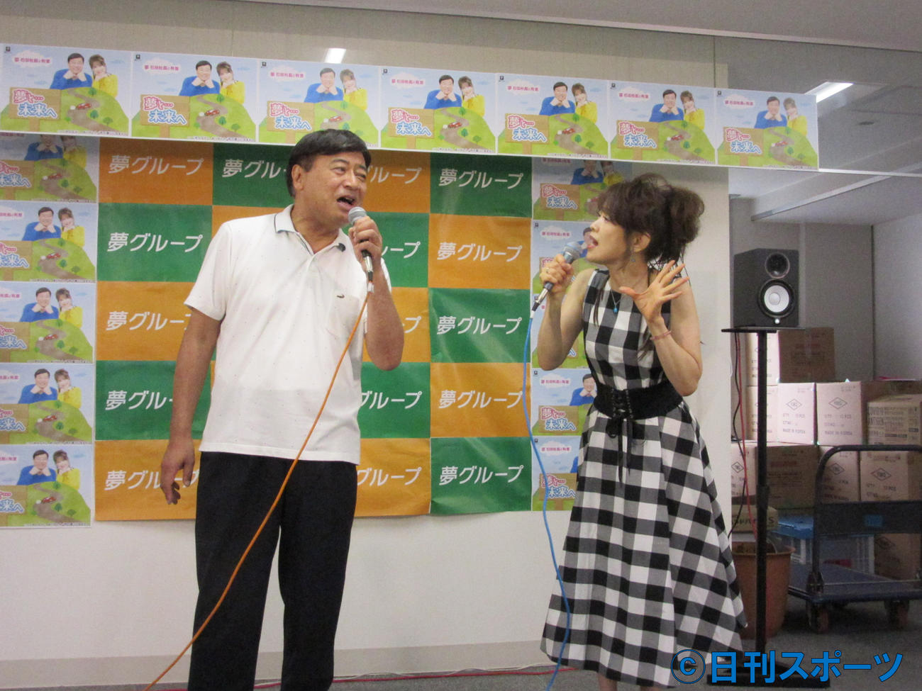 保科有里（右）と歌手デビュー曲を披露する石田重廣社長（8日、東京・文京区の夢グループ本社）