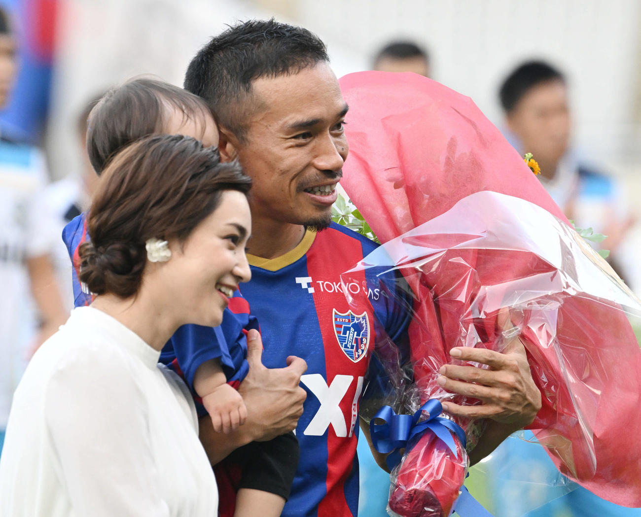 2022年7月17日、東京対磐田　試合前にJ1通算100試合を達成した東京長友（奥）は妻の平愛梨（手前）ら家族から花束を受け取る
