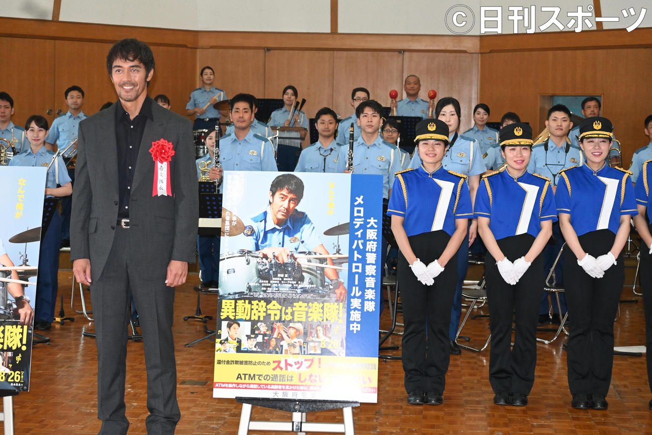 大阪府警察音楽隊と大阪府警察カラーガード隊のメンバーと記念撮影する阿部寛（撮影・松浦隆司）