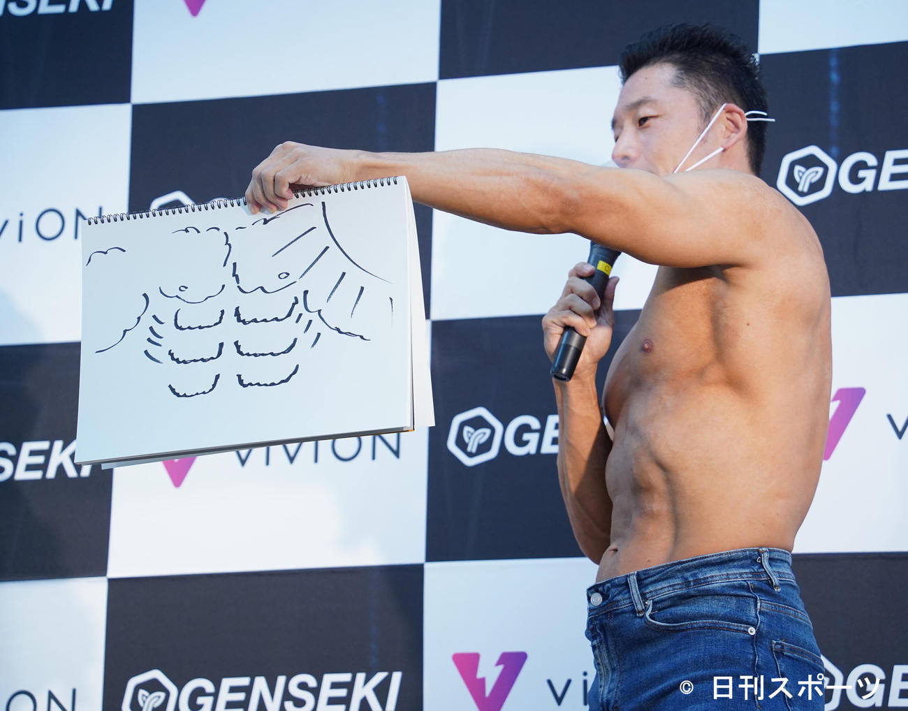 「筋肉イラストコンテスト授賞式」に登壇した、なかやまきんに君は、イラストを見せる（撮影・佐藤勝亮）