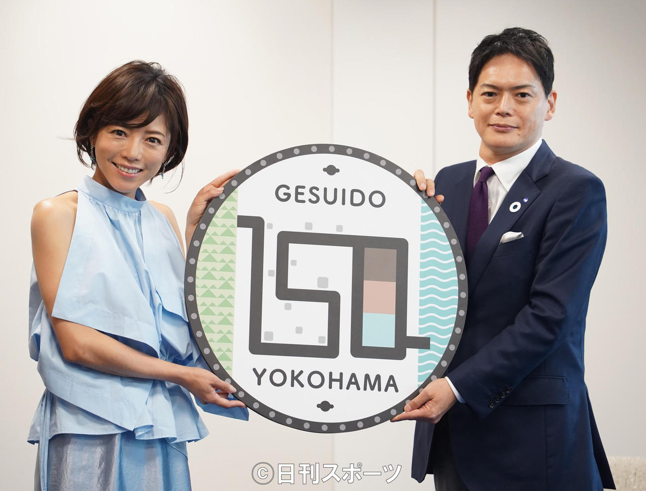 「横浜下水道150広報大使」に就任し、マンホールのレプリカを贈られる釈由美子（左）。右は山中竹春横浜市長（撮影・佐藤勝亮）