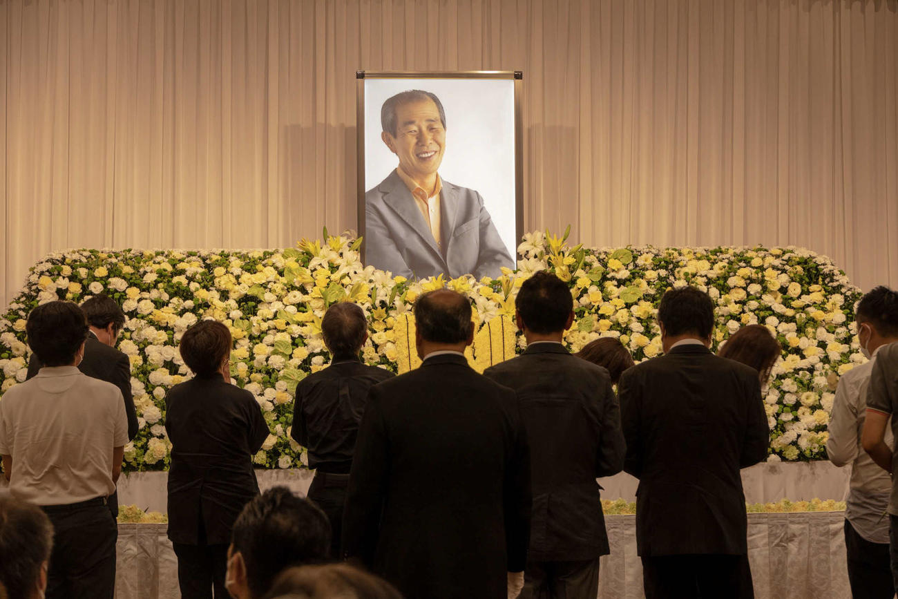 佐々木史朗さんのお別れの会で、祭壇に献花する参列者