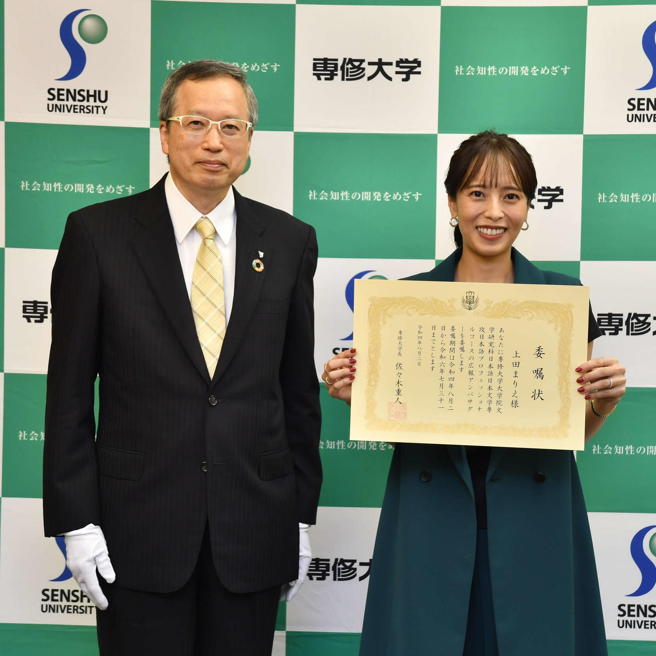 専修大大学院日本語プロフェッショナルコースの広報アンバサダーに就任し、委嘱状を受ける上田まりえ（右）。左は佐々木重人学長