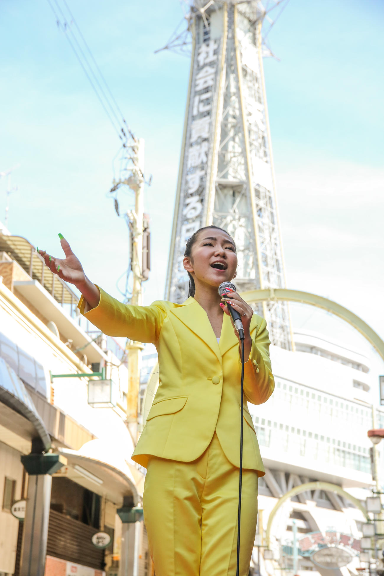 通天閣をバックに新曲「大阪ロンリネス」を熱唱する田中あいみ