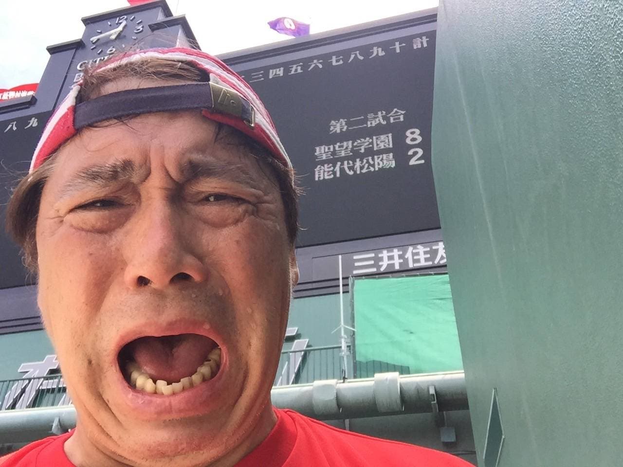 聖望学園が能代松陽を8－2で破ったバックスクリーンのスコアをバックに感極まる寺田体育の日