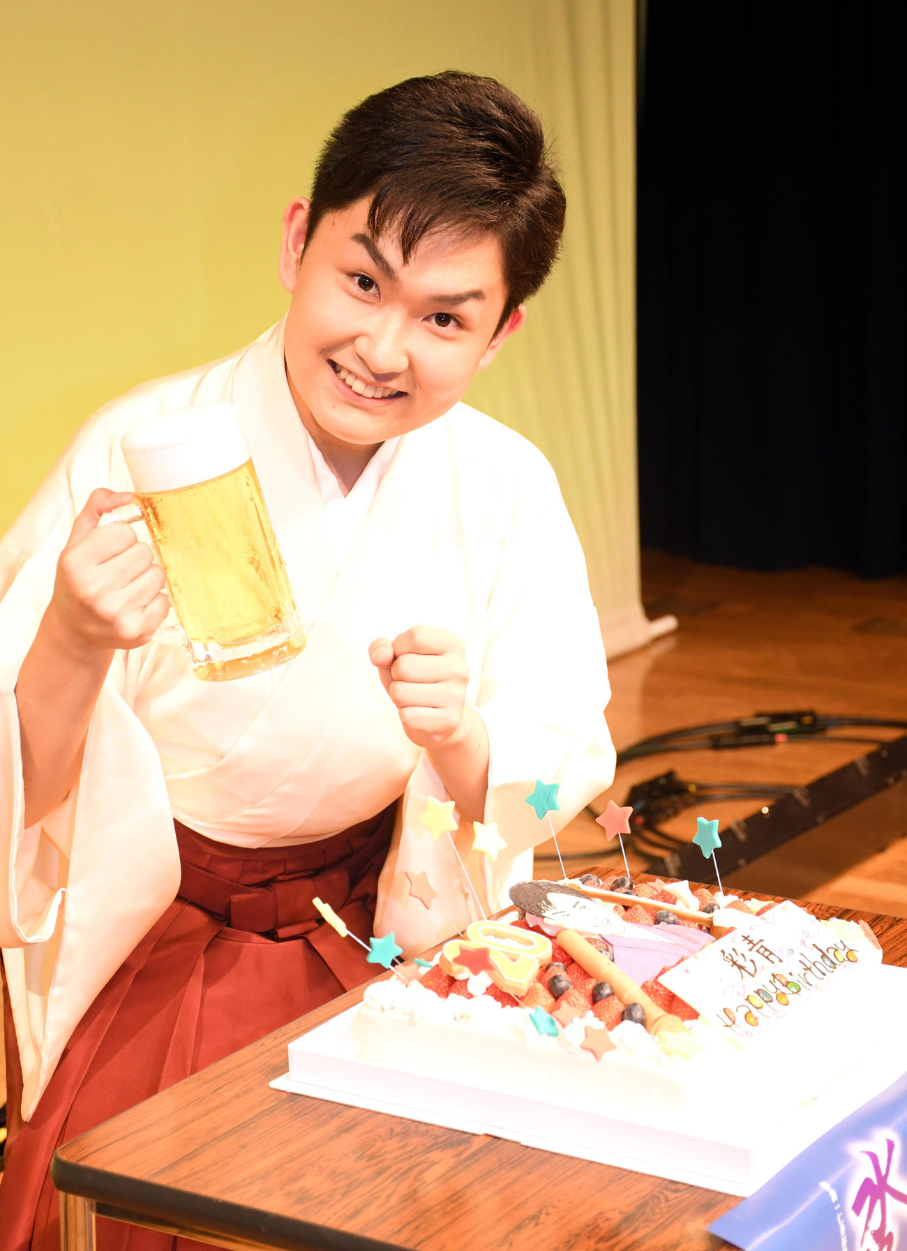 ファーストコンサートを終えて20歳の誕生日を前にビールのサンプルを手にポーズをとる彩青（撮影・大友陽平）