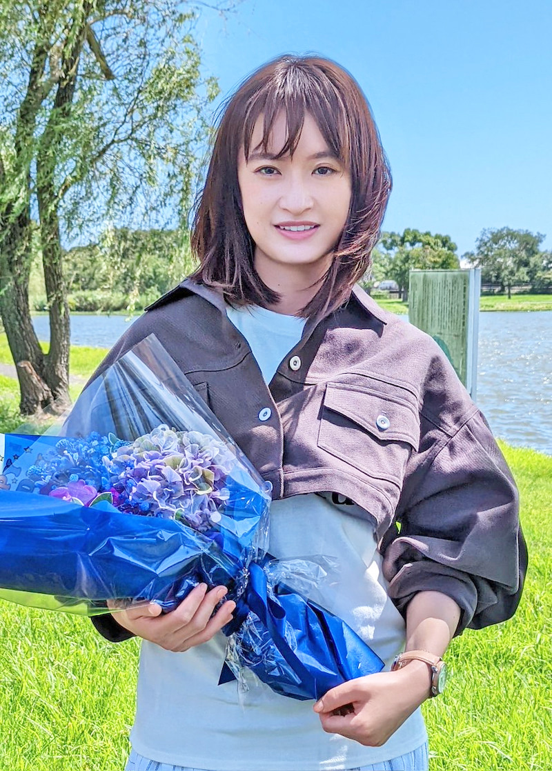 夏空の下でお祝いの花束を持つ門脇（ドラマ「親愛なる僕へ殺意をこめて」オフィシャルブログより）