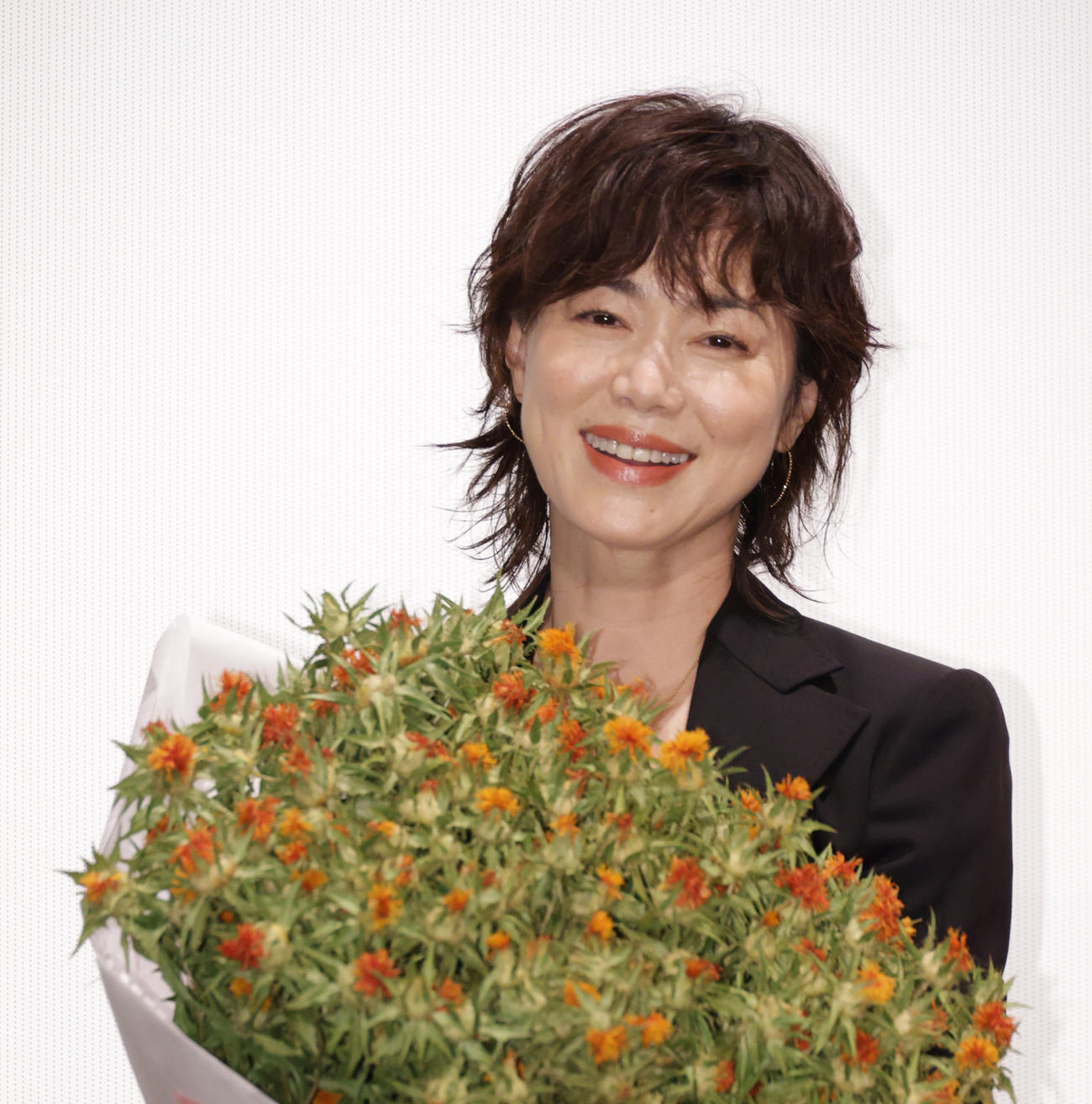 紅花の花束を抱え映画「紅花の守人」初日舞台あいさつを行う今井美樹（撮影・中島郁夫）