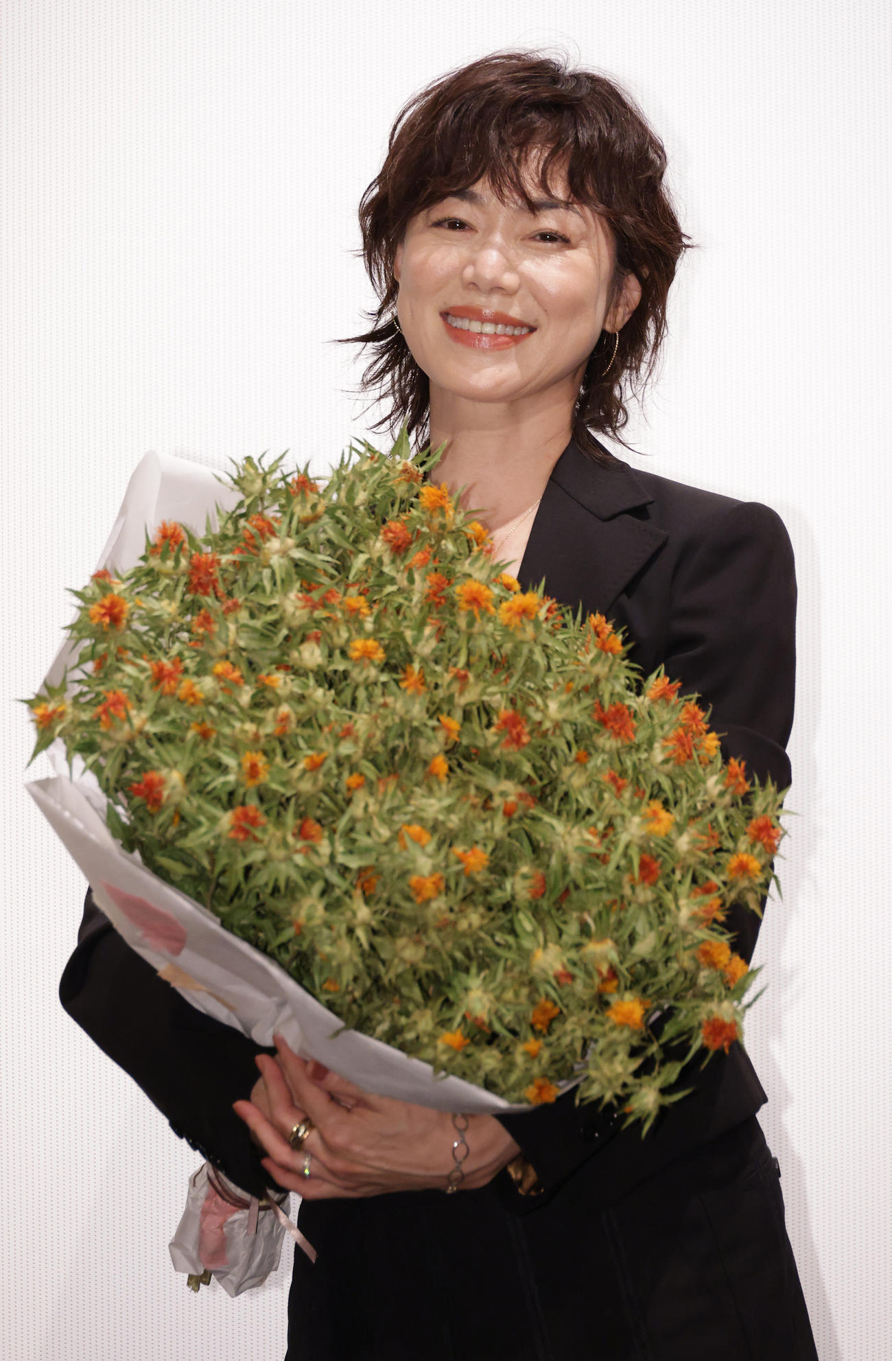 紅花の花束を抱え映画「紅花の守人」初日舞台あいさつを行う今井美樹（撮影・中島郁夫）