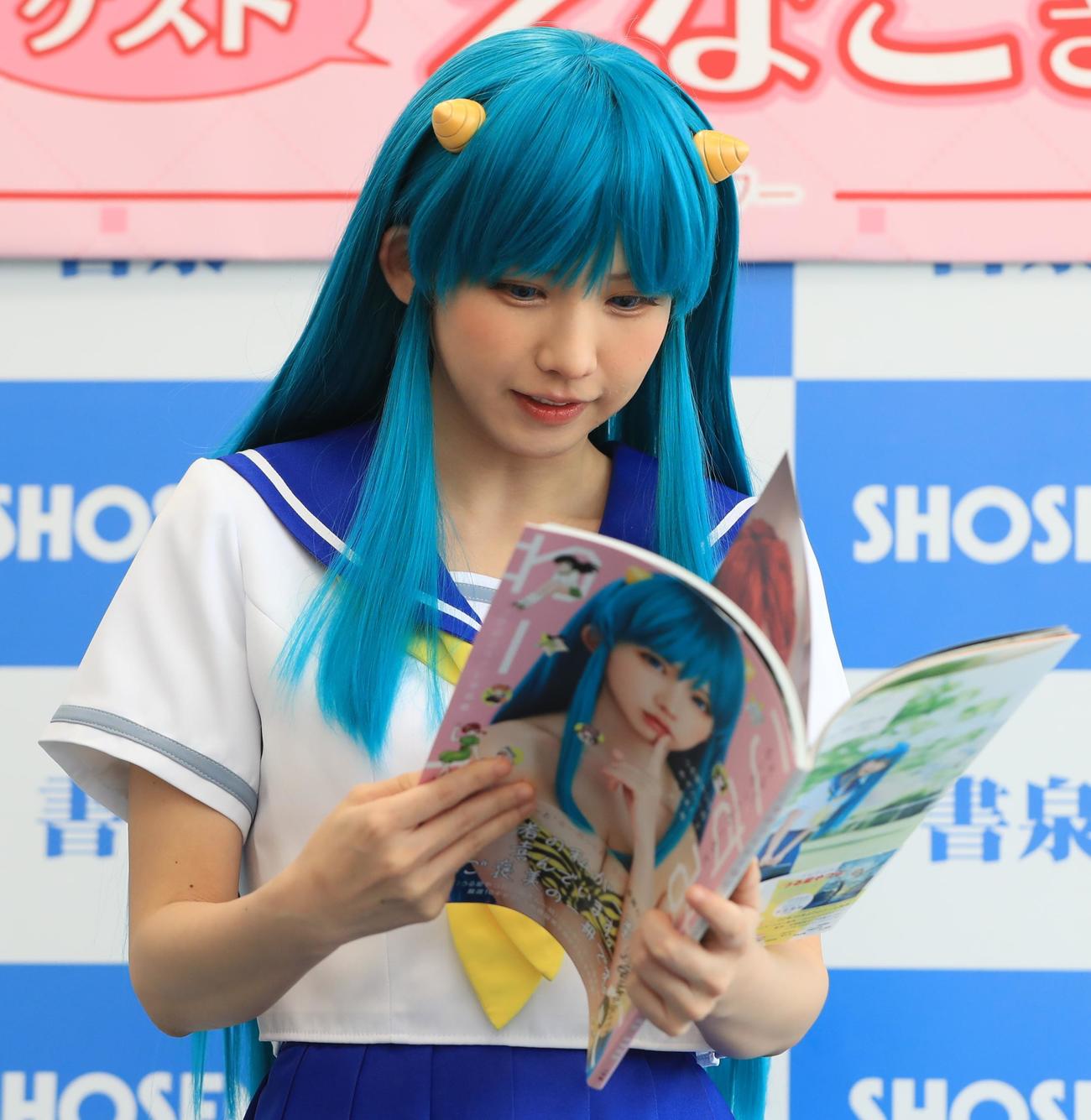 コスプレ写真集「こすみっくわーるど」発売記念イベントに登壇しお気に入りのページを探すえなこ（撮影・藤塚大輔）